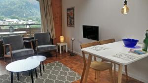a living room with a table and chairs and a television at Balcony of lake Geneva in Thollon