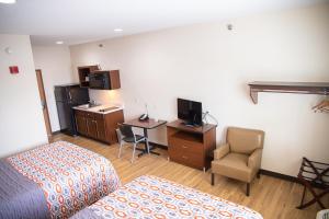 um quarto de hotel com uma cama e uma secretária com um computador em White House Suites em Plainfield