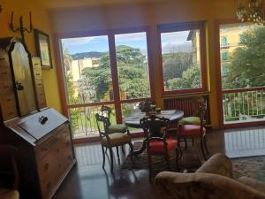 ein Esszimmer mit einem Tisch und Stühlen sowie großen Fenstern in der Unterkunft Benvenuti A Casa Incerpi in Montecatini Terme