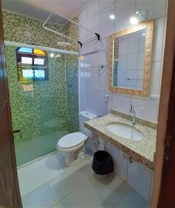y baño con aseo, lavabo y ducha. en Morada dos Colibris, en Boicucanga