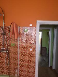蒙特卡蒂尼泰爾梅的住宿－Benvenuti A Casa Incerpi，一间铺有瓷砖的墙壁和淋浴的浴室