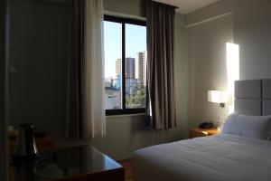 a hotel room with a bed and a window at Cot Hotel (ቆጥ ሆቴል) in Addis Ababa