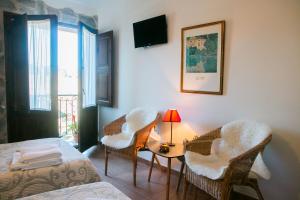 um quarto com duas camas e uma mesa com cadeiras em Posada El Tesin em Rabanal del Camino