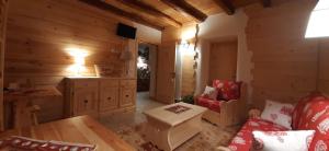 Cabaña de madera con sala de estar con sofá y mesa en B&B SognoInCadore, en Domegge di Cadore