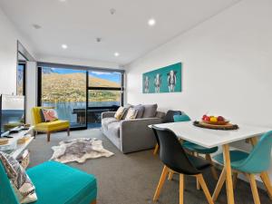 - un salon avec un canapé et une table dans l'établissement Residence du Lac by Staysouth, à Queenstown