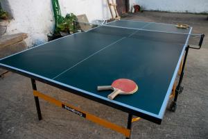 una mesa de ping pong con una paleta de ping pong en Casona de Rabanal-Oca en Rabanal del Camino