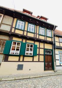 クヴェードリンブルクにあるFerienwohnungen Word 5 Altstadt Quedlinburgの通路の緑と黄色の窓がある建物