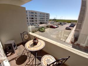 a balcony with a table and chairs and a view of a parking lot at DEPARTAMENTO AVENIDA PACIFICO. SECTOR PUERTA DEL MAR in La Serena