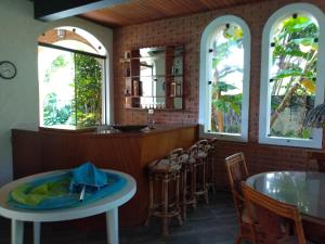 um restaurante com três janelas e uma mesa e cadeiras em Casa com piscina em condomínio fechado no Guarujá em São Paulo