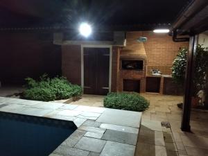 uma casa com um pátio à noite com uma luz em Casa com piscina em condomínio fechado no Guarujá em São Paulo