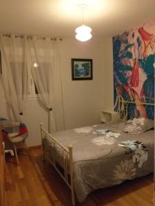 ein Schlafzimmer mit einem Bett und einem Wandgemälde in der Unterkunft Chez Mamie Riclaude in Orsan