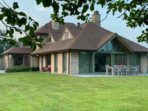 una casa con techo inclinado y césped en vakantiewoning le jardin de grand-mére en Oudenburg