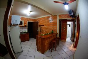 cocina con barra y pared de ladrillo en Cabanas do Mirante, en Imbituba