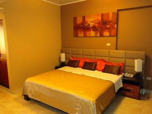 1 dormitorio con 1 cama grande con almohadas de color naranja en Gran Hotel Ica, en Ica