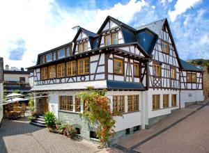 ein großes weißes und schwarzes Gebäude mit Fenstern in der Unterkunft Landgasthof Rebstock in Sankt Goar