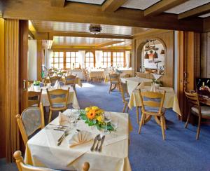 una sala da pranzo con tavoli e sedie bianchi di Landgasthof Rebstock a Sankt Goar