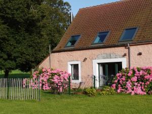 una casa con flores rosas delante de ella en Gîte de la Ferme Rose, en Audembert