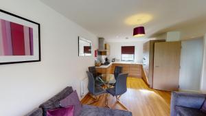 sala de estar con mesa y sillas y cocina en Niche Parkview Apartments en Brentwood