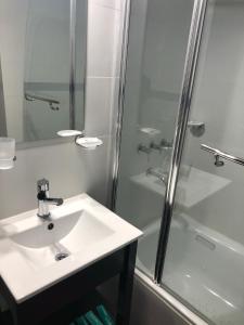 La salle de bains est pourvue d'un lavabo et d'une douche. dans l'établissement PlaceresCC, à Ushuaia