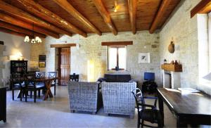 a dining room with tables and chairs and a stone wall at Villa Talea in Exándis