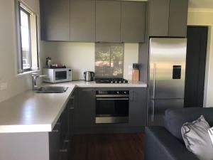 a kitchen with a stove and a refrigerator at Twizel - Apartment on Woodley in Twizel