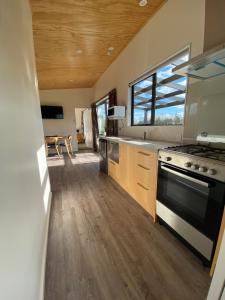 a large kitchen with a stove and a window at Country Retreats on Ranzau 1 in Nelson