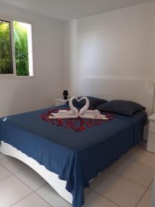 ein Schlafzimmer mit einem Bett mit zwei Schwänen darauf in der Unterkunft Gîtes de Corneille, Bungalow Sweet Mango in Le Moule