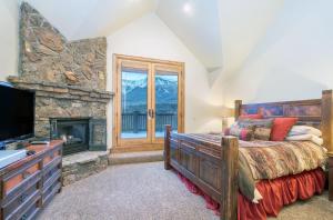 um quarto com uma cama grande e uma lareira em Adams Ranch Rd - 249 em Telluride