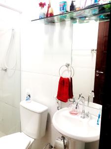 a white bathroom with a toilet and a sink at Quarto - Condomínio in Macapá