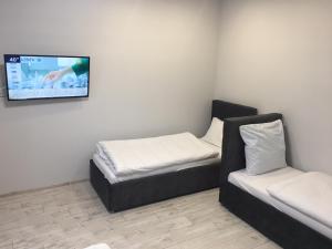 a room with two beds and a tv on the wall at APARTMENT EDELWEISS in Uzhhorod