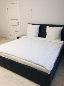 a large bed with white sheets and pillows on it at APARTMENT EDELWEISS in Uzhhorod