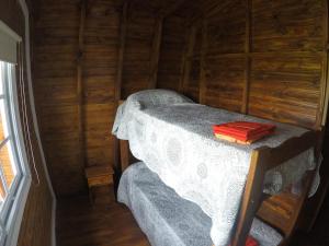 1 dormitorio con 1 cama en una cabaña de madera en Cabañas del Lagarto en Colón