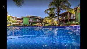 a large swimming pool in front of some houses at Bangalô duplex à beira-mar in Camaçari