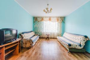 a living room with two couches and a tv at Dekabrist Apartment at anokhina 93 in Chita