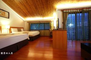 池南村的住宿－潭心閣民宿，酒店客房设有两张床和木制天花板。