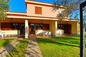 a house with a lawn in front of it at Residence Li Menduli in San Teodoro