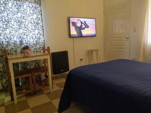 - une chambre avec un lit et une télévision murale dans l'établissement MG Suites, à Monte Grande