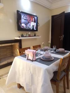 d'une salle à manger avec une table et une télévision murale. dans l'établissement Apartment with Terrace, à Casablanca