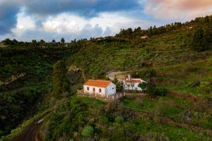an aerial view of a house on a hill at "Rural House Servanda" - RELAX, NATURE, WIDE VIEWS OF THE SEA AND A STARRY SKY in Puntagorda