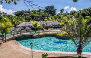 einen Pool in einem Resort mit Palmen in der Unterkunft Rio Quente Luupi- Apartamento-131 P in Rio Quente