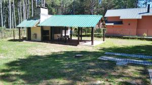 uma casa com um telhado verde num quintal em Casa de descanso em Colonia Estrella