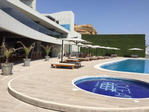 un complexe avec une piscine, des tables et des parasols dans l'établissement Vive - Descansa - Disfruta, à San Bartolo