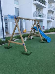 a playground with a slide and a blue slideintend at Apartamento Girardot Espectacular Vista!! in Girardot
