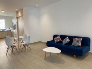 - un salon avec un canapé bleu et une table dans l'établissement Vive - Descansa - Disfruta, à San Bartolo