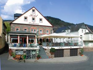 ein großes Backsteingebäude mit einem Restaurant davor in der Unterkunft Hotel Moselterrasse in Ediger-Eller