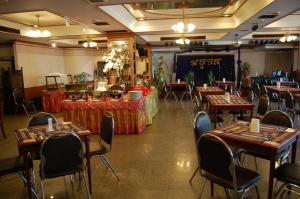 a restaurant with tables and chairs in a room at Chiangmai Ratanakosin Hotel in Chiang Mai
