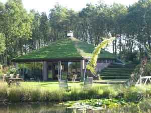 a gazebo with a green roof and a roller coaster at Selatuinen in Appelscha