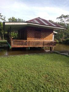 une maison avec une terrasse dans l'eau dans l'établissement Green Lodge Tangkahan, à Tangkahan