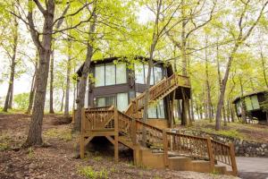 une maison avec une grande terrasse dans les bois dans l'établissement Unit 9 - Treetop 2 Bedroom Villa, à Four Seasons