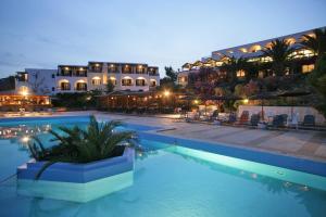 un hotel con piscina frente a un edificio en Andros Holiday Hotel en Gavrio